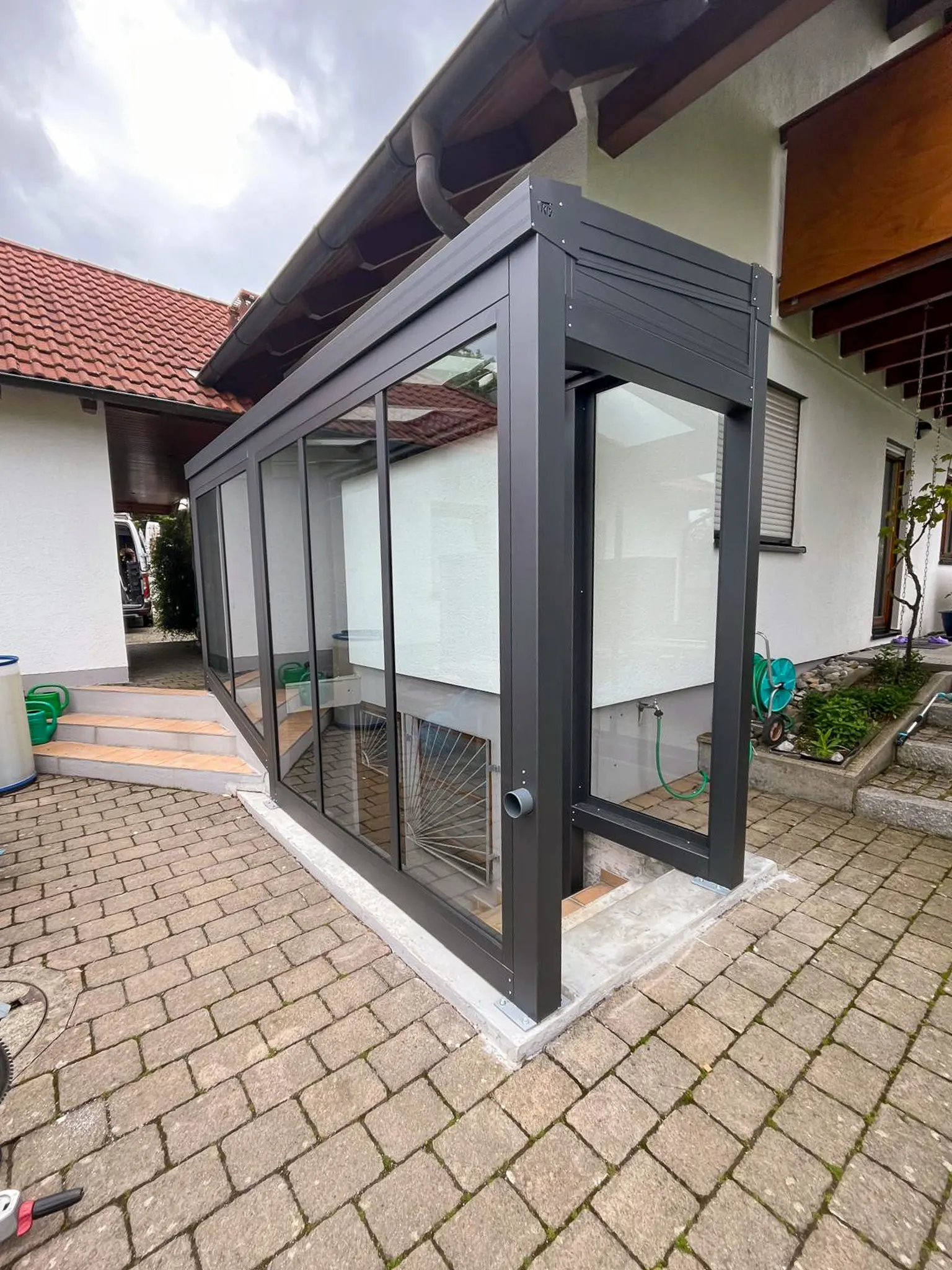 Kompakter Kaltwintergarten aus Aluminium und Glas an Hauseingang